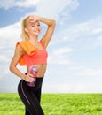 Smiling sporty woman with towel and water bottle Royalty Free Stock Photo