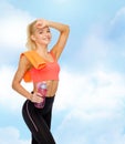 Smiling sporty woman with towel and water bottle Royalty Free Stock Photo