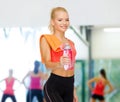 Smiling sporty woman with water bottle and towel Royalty Free Stock Photo