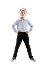 Smiling standing schoolboy in santa claus hat. Full height. Christmas mood. Isolated over white background. Royalty Free Stock Photo