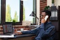 Smiling startup worker sitting at desk with laptop discussing business performance results on the phone Royalty Free Stock Photo