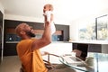 Smiling Stay At Home African American Father Cuddling Baby Daughter Whilst Working On Laptop At Home Royalty Free Stock Photo