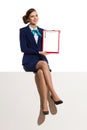 Smiling Stewardess Sitting On A Top And Showing Clipboard