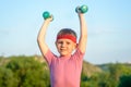 Smiling Strong Boy Raising Two Dumbbells