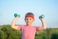 Smiling Strong Boy Raising Two Dumbbells