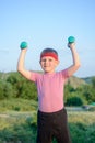 Smiling Strong Boy Raising Two Dumbbells