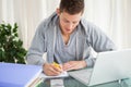 Smiling student doing his homework with a laptop Royalty Free Stock Photo