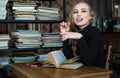 Smiling student girl in the library studying and day dreaming, she is thinking with hand on chin and looking up Royalty Free Stock Photo