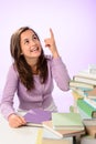 Smiling student girl pointing up purple background Royalty Free Stock Photo