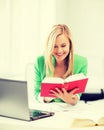 Smiling student girl reading book in college Royalty Free Stock Photo