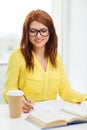 Smiling student girl reading books in library Royalty Free Stock Photo