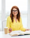 Smiling student girl reading books in library Royalty Free Stock Photo