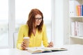 Smiling student girl reading books in library Royalty Free Stock Photo