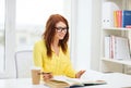 Smiling student girl reading books in library Royalty Free Stock Photo