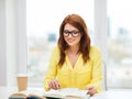 Smiling student girl reading books in library Royalty Free Stock Photo
