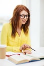 Smiling student girl reading books in library Royalty Free Stock Photo