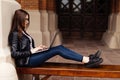 Smiling student girl sitting on bench in park, working with laptop and taking notes, preparing for exams outdoors, having rest in Royalty Free Stock Photo