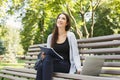 Smiling student girl sitting in park using laptop Royalty Free Stock Photo