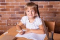 Smiling student girl sitting at a school desk and studying math. The child is doing homework. Preschool education Royalty Free Stock Photo