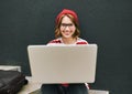 Smiling student girl using laptop computer while sitting outside on staircase, studying online Royalty Free Stock Photo