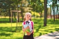 Smiling student girl wearing school backpack and holding exercise book. Portrait of happy Caucasian young girl outside Royalty Free Stock Photo