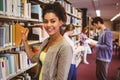 Smiling student picking out a book Royalty Free Stock Photo