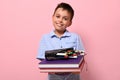 A smiling student at school, holds books in front of him and pencil case with pens, felt-tip pens and markers falling out of him. Royalty Free Stock Photo