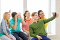 Smiling students making picture with tablet pc