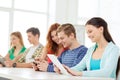 Smiling students with tablet pc at school