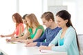 Smiling students with textbooks at school Royalty Free Stock Photo