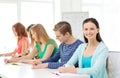 Smiling students with textbooks at school Royalty Free Stock Photo