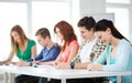 Smiling students with textbooks at school Royalty Free Stock Photo