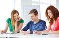 Smiling students with textbooks at school Royalty Free Stock Photo