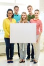 Smiling students with white blank board at school Royalty Free Stock Photo