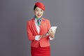 smiling stylish air hostess asian woman against gray background Royalty Free Stock Photo