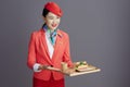 smiling stylish air hostess asian woman isolated on gray Royalty Free Stock Photo