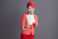 smiling stylish asian female air hostess against grey Royalty Free Stock Photo