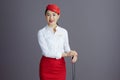 smiling stylish asian female stewardess isolated on gray Royalty Free Stock Photo