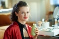 Woman with bottle of yoghurt in modern living room in sunny day