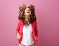Smiling stylish woman isolated on pink shaking hair