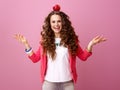 Smiling stylish woman on pink background with an apple on head