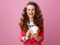Smiling stylish woman showing farm organic yogurt and spoon