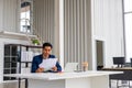 Successful businessman holding document sitting at desk, reading good news in letter, reviewing beneficial lucrative