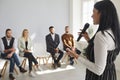 Smiling female coach talk at training with employees