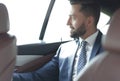 Smiling business man sitting in the back seat of a car Royalty Free Stock Photo