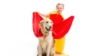 Smiling supergirl expanding red cape on golden retriever