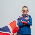 Smiling superhero boy with British flag cape