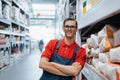 smiling supervisor standing next to a rack of plaster. Royalty Free Stock Photo