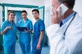 Smiling surgeons standing together with clipboard in corridor Royalty Free Stock Photo