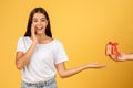 Smiling surprised young european woman take box present from man hand Royalty Free Stock Photo